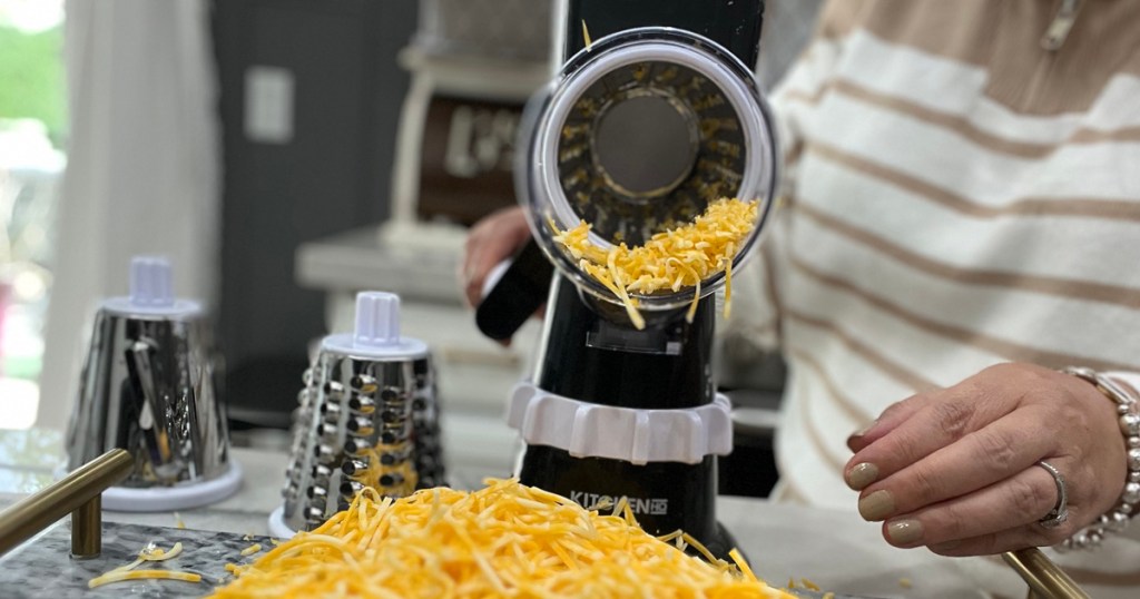 Kitchen HQ Speed Grater and Slicer being used by a person in a kitchen to shred cheese