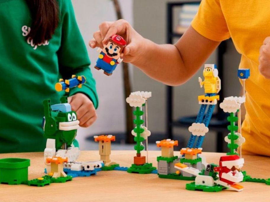 2 kids playing with a LEGO Super Mario Big Spike’s Cloudtop Challenge Expansion Set