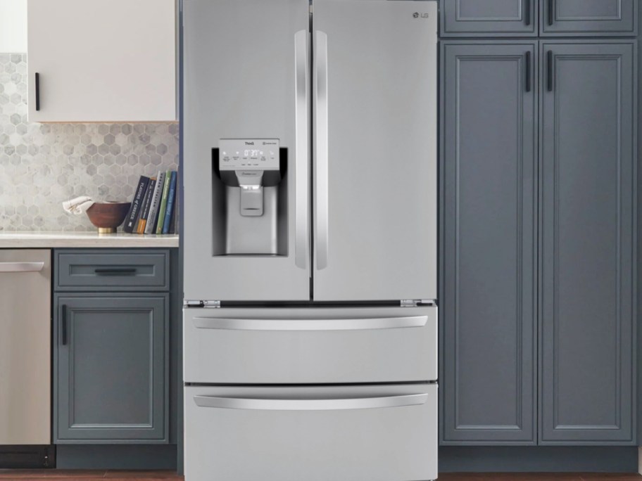 stainless steel fridge in kitchen with blue cabinets