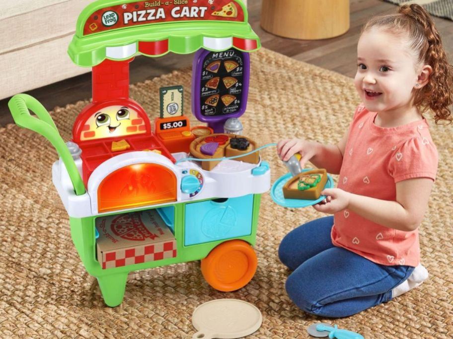 A child playing with a LeapFrog Build-a-Slice Pizza Cart 