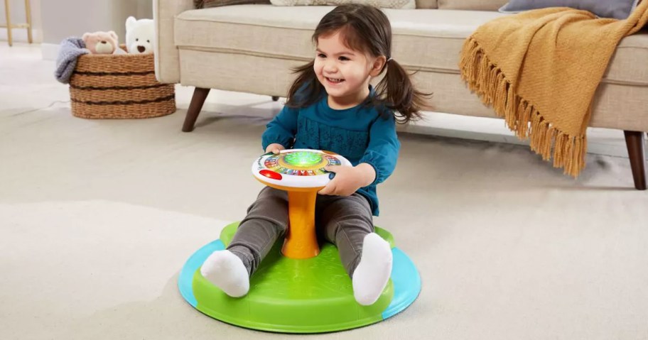 girl spinning around on leapfrog toy in living room