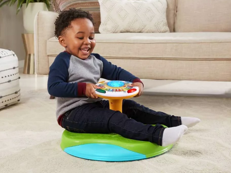 boy spinning around on leapfrog toy in living room