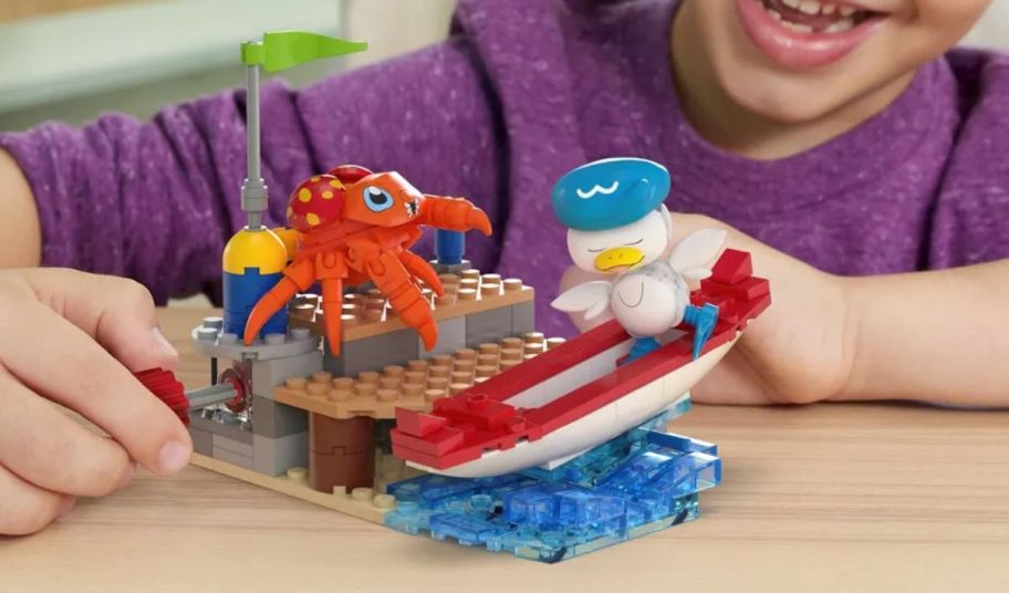a kid playing with a a MEGA Pokemon Quaxly and Paras Building Kit 