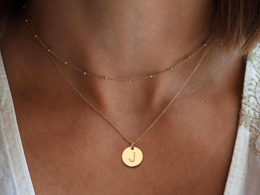 A woman wearing a MOOHAM Initial Necklace in gold