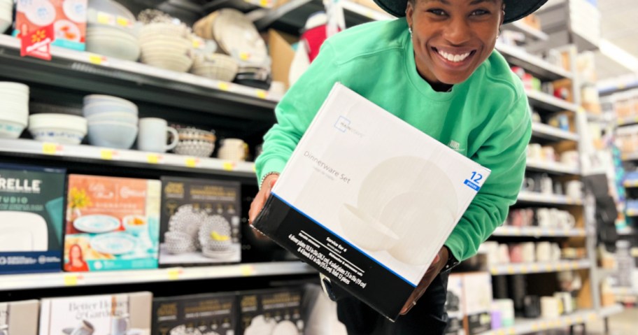 woman in store holding up box of mainstay dinnerware