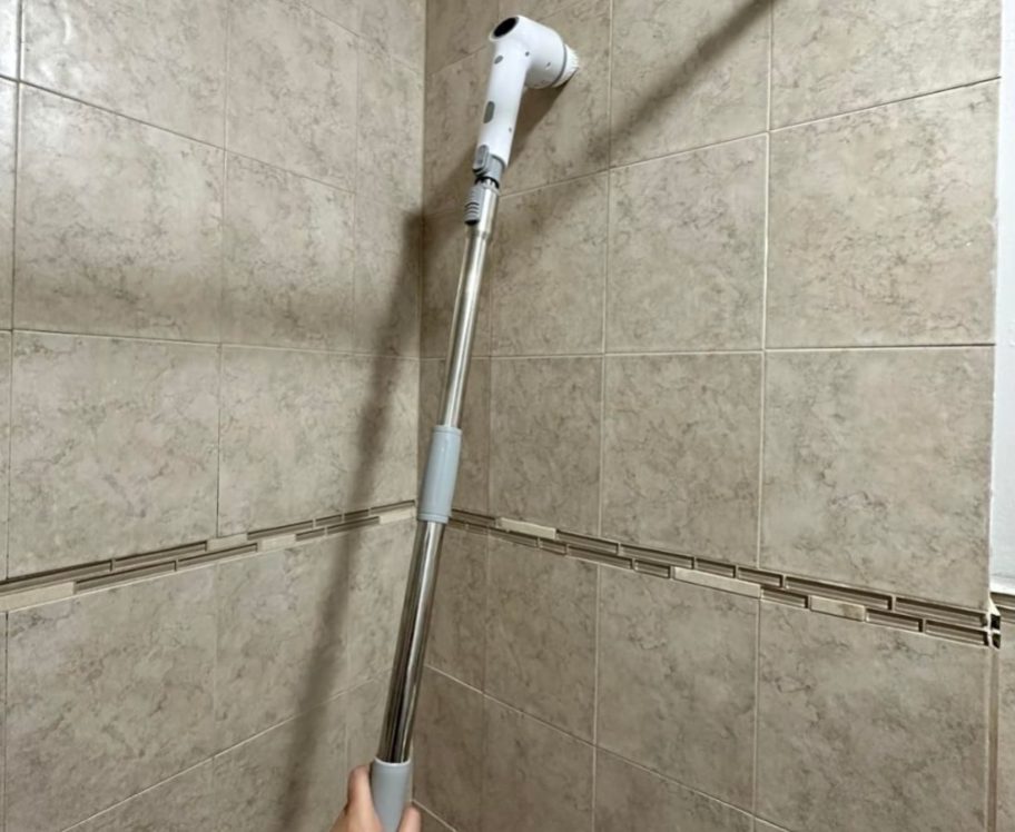 A Maxdoria power scrubber being used to clean a shower