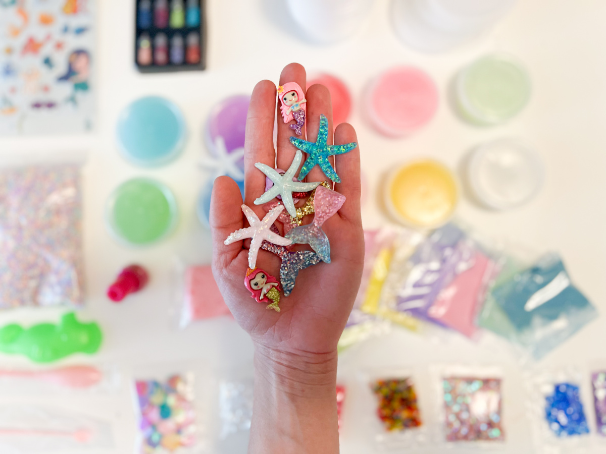 hand holding Mermaid themed beads for a slime kit