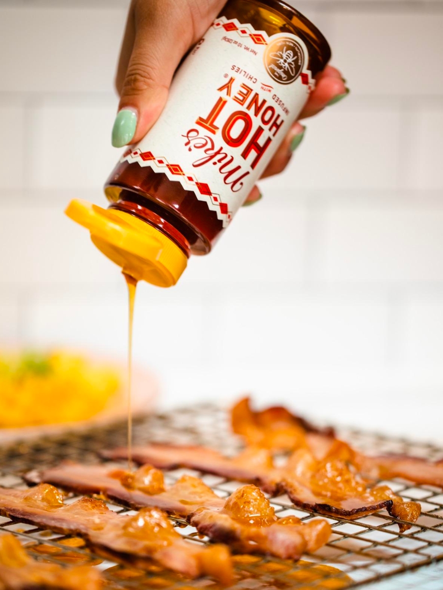 Mike's Hot Honey 10oz Bottle with cooked bacon