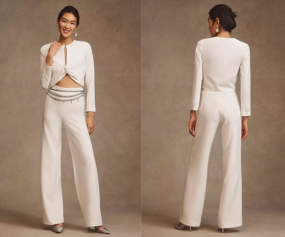 a woman wearing a white long sleeve knotted front blouse with a pair of white wide leg pants