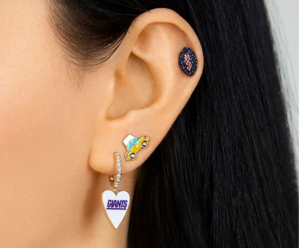 A womans ear with three earrings