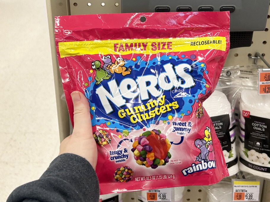 hand holding up a large pink bag of Nerds Gummy Clusters 