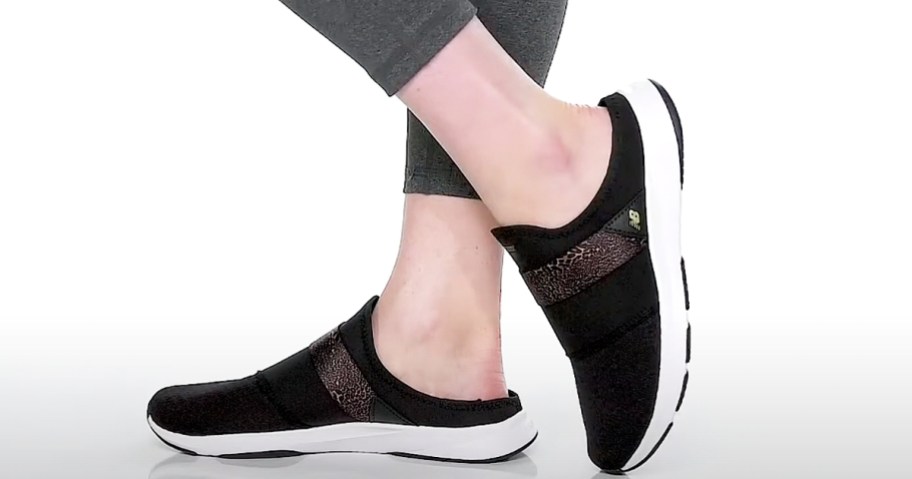 woman wearing black slip-on new balance sneakers