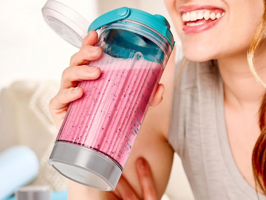 Woman drinking from the blending cup from a Ninja Blast Personal Blender