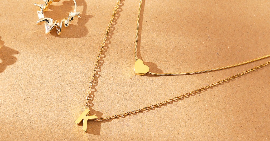 gold initial letter K necklace layered with small heart pendant necklace