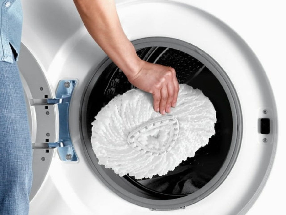 woman tossing a O-Cedar EasyWring Microfiber Spin Mop head into a washing machine