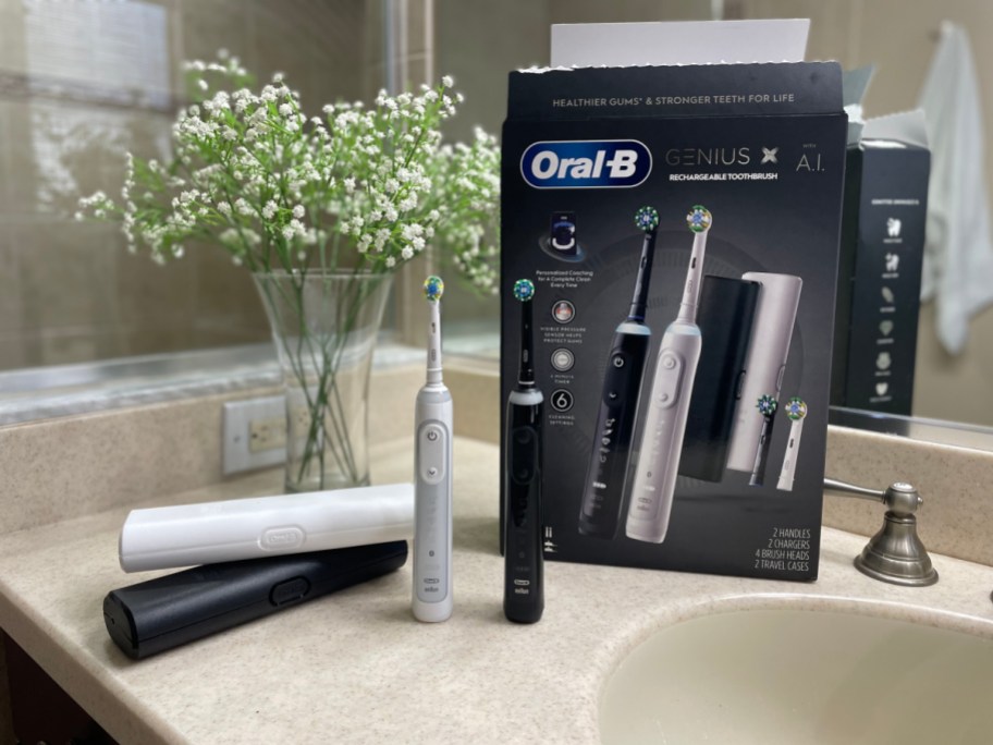 Oral B Genius Electric Toothbrushes and matching travel cases on a bathroom counter