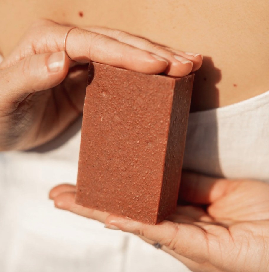 Hands holding a brown colored soap free cleansing bar