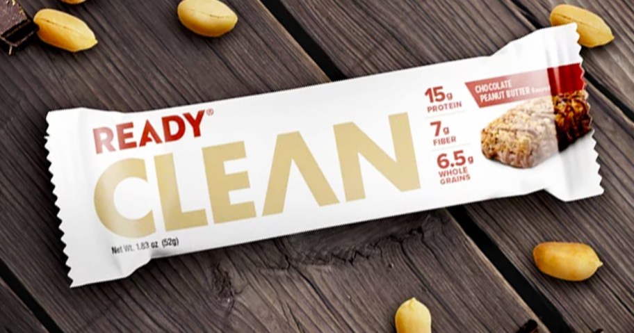 Ready Clean Protein Bar on wood table near peanuts and chocolate