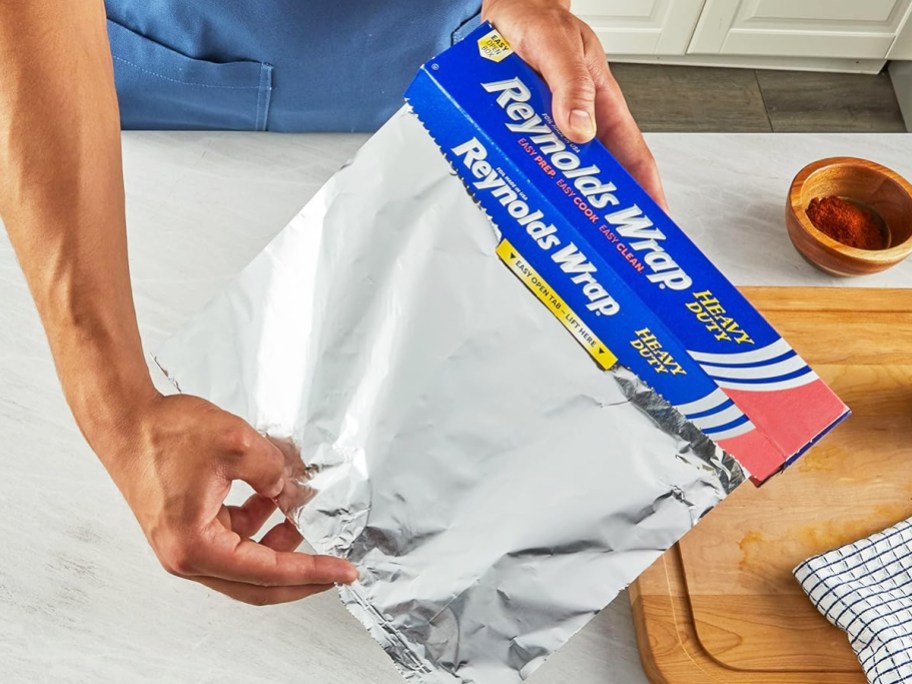 person pulling out a piece of foil from box