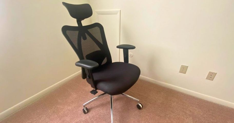 tall black office chair with headrest and arm rests sitting in a room