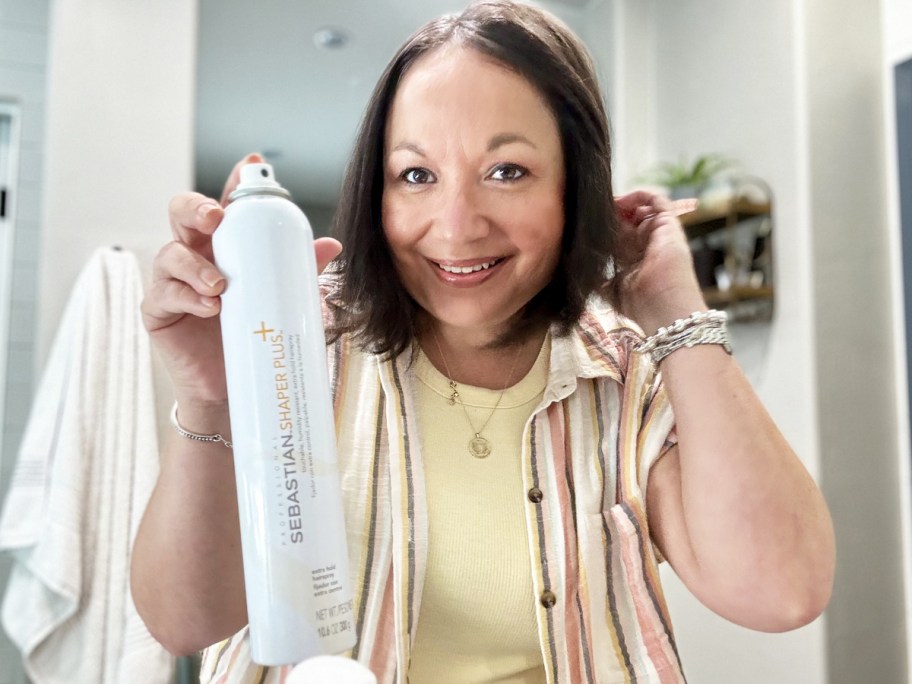 woman holding up a white can of Sebastian hairspray