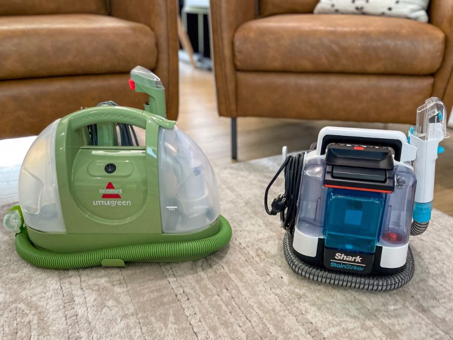 A bissell little green and shark stainstriker machine next to each other on a carpeted floor