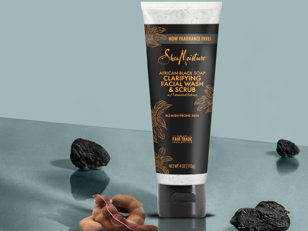 SheaMoisture Facial Wash and Scrub displayed with charcoal and tamarind around it