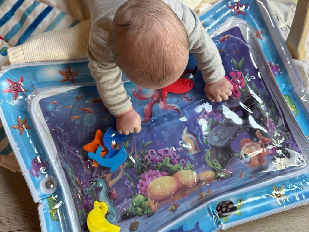 A baby on a Splashin' kids Inflatable Tummy Time Mat Blue