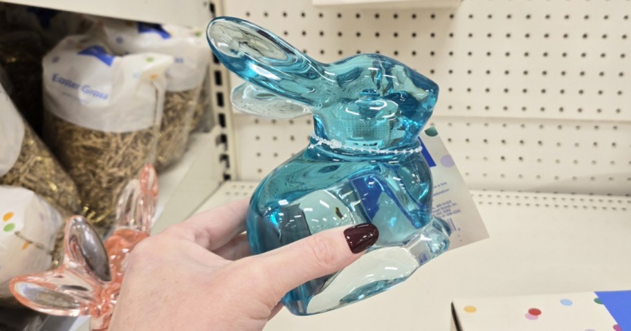 hand holding up a blue bunny figurine in store