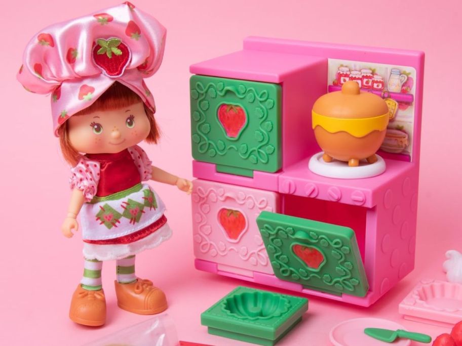 A Strawberry Shortcake Doll with an oven and baking materials
