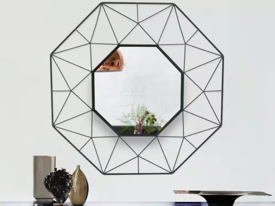 black framed octagon shaped mirror on white wall