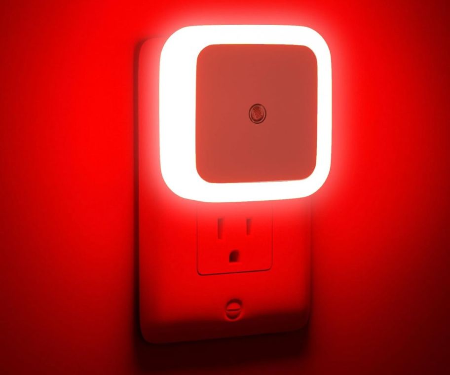 a soft red night light plugged into an electrical receptacle