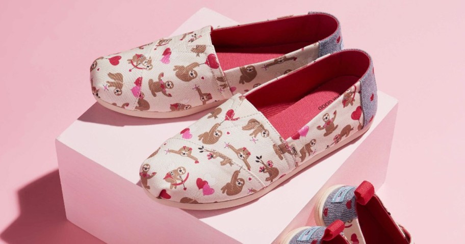 pair of sloth & heart print sneakers on top of pink box