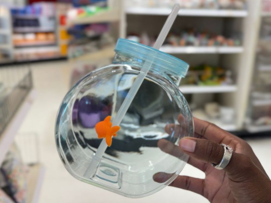 Hand holding up a Golfish Bowl shaped Sipper cup from the Bullseye Playground at Target
