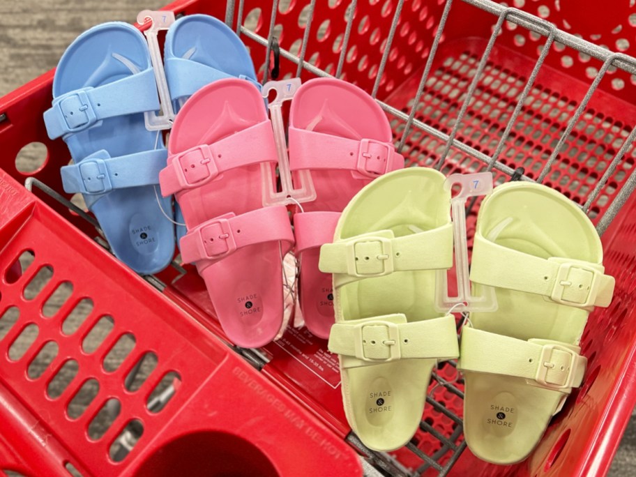 blue, pink, and bright green pairs of sandals in red target shopping cart