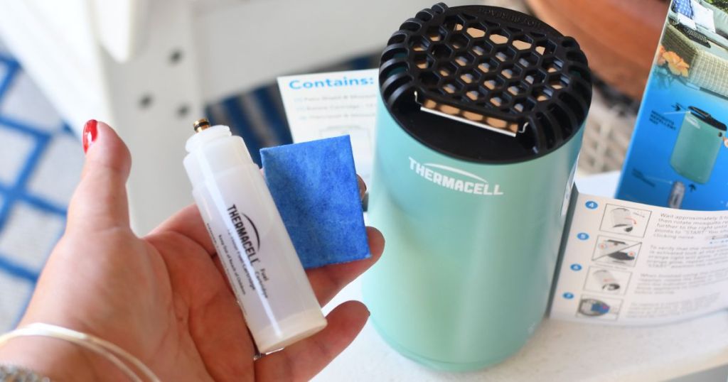 Hand holding a Thermacell Refill next to a Thermacell Repeller