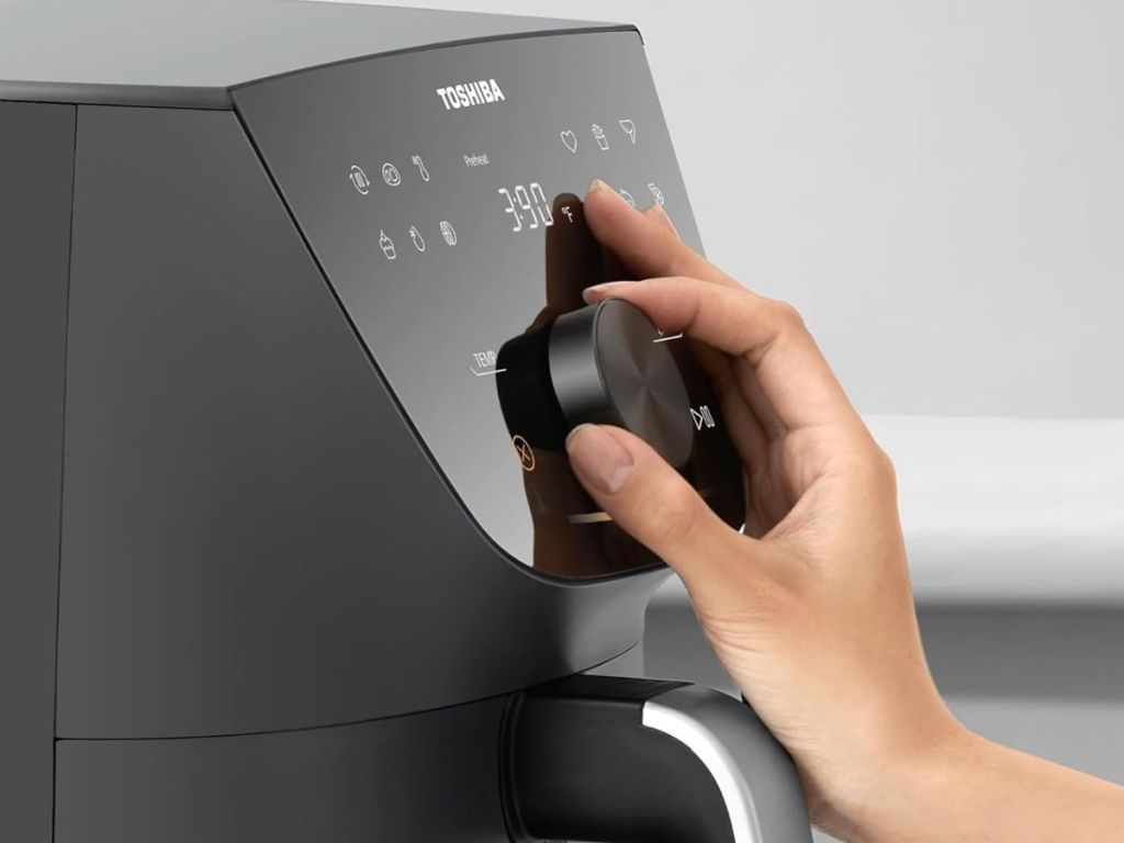 hand adjusting the knob on a Toshiba 7.7qt Air Fryer 