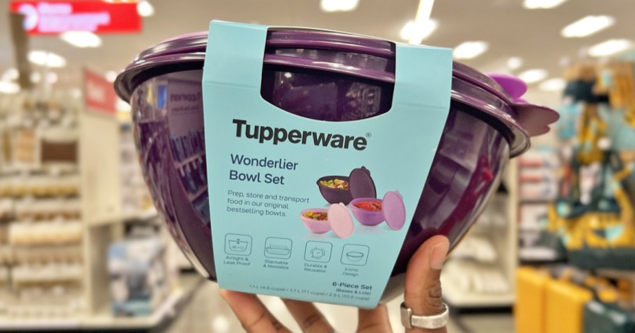 hand holding up a set of purple tupperware bowls in store