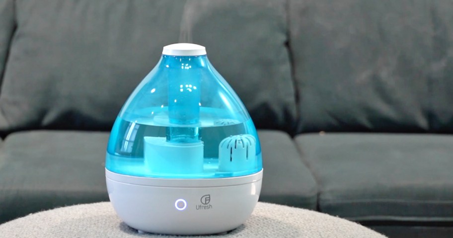 blue and white humidifier on coffee table in front of couch