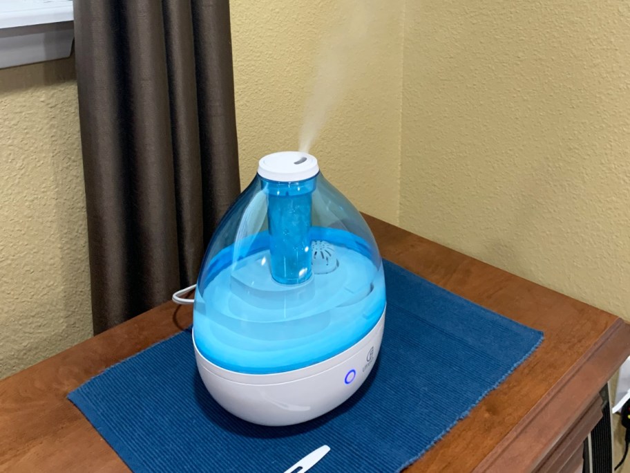 blue and white humidifier on blue placemat on a wood table