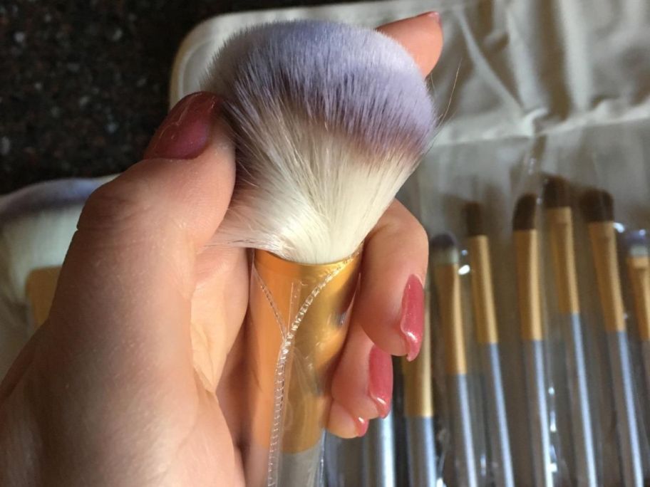Hand holding a Vander makeup brush and showing the quality of the bristles