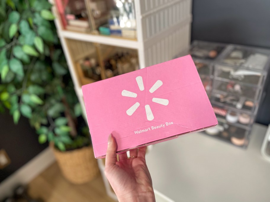 Woman holding up pink Walmart, beauty box