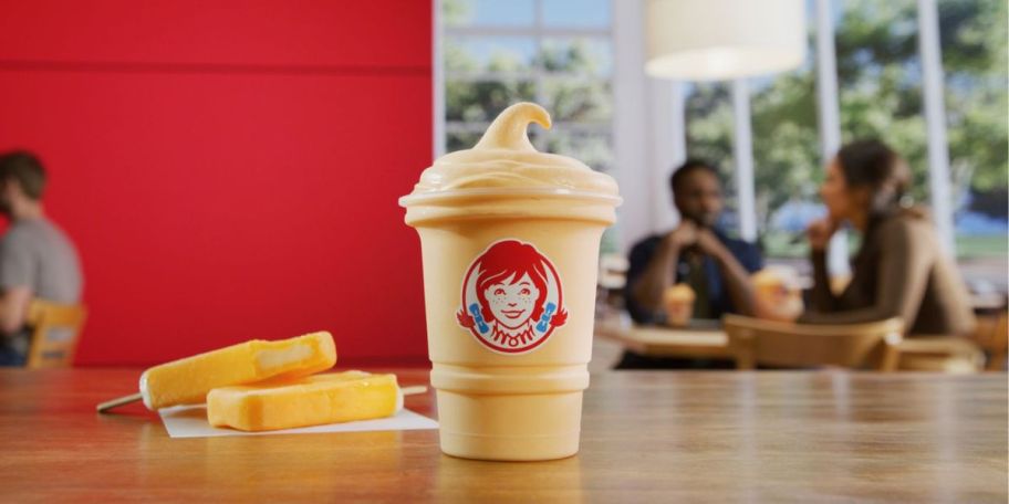 Wendy's Orange Dreamsicle Frosty on table with orange dreamsicles next to it