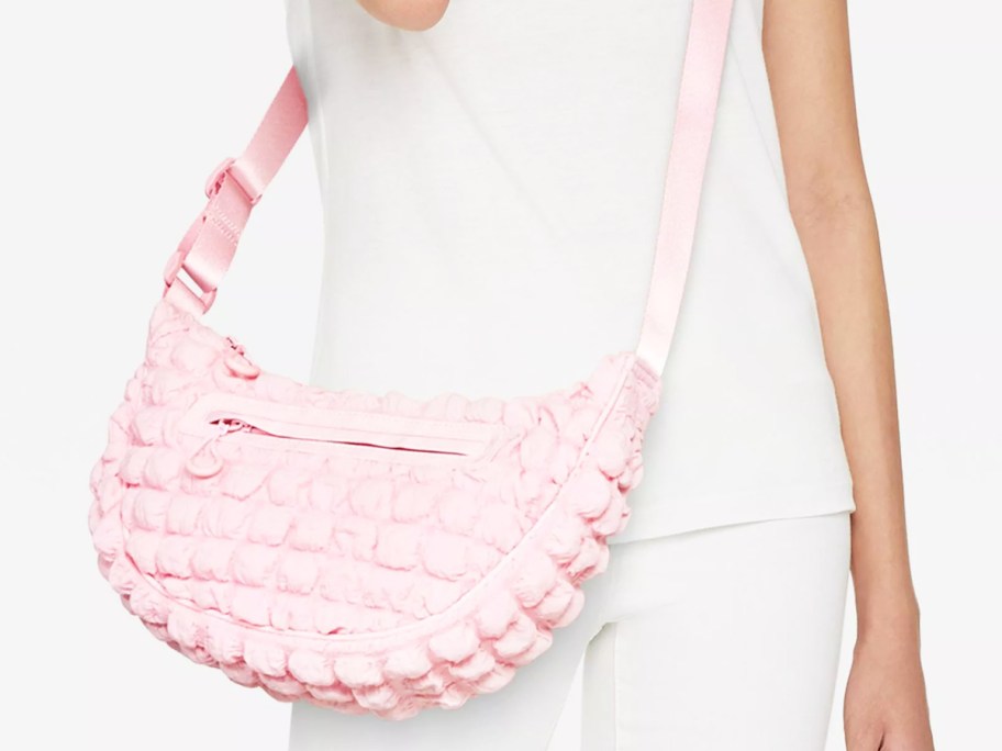 woman with light pink puffy half-moon bag