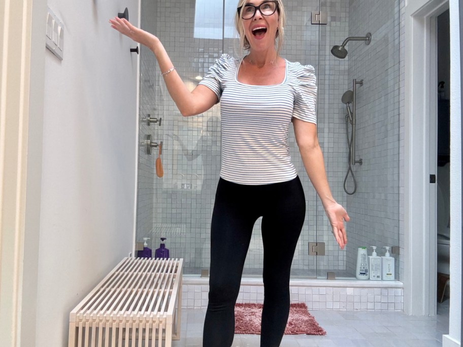 Woman wearing amazon top with black pants in her bathroom