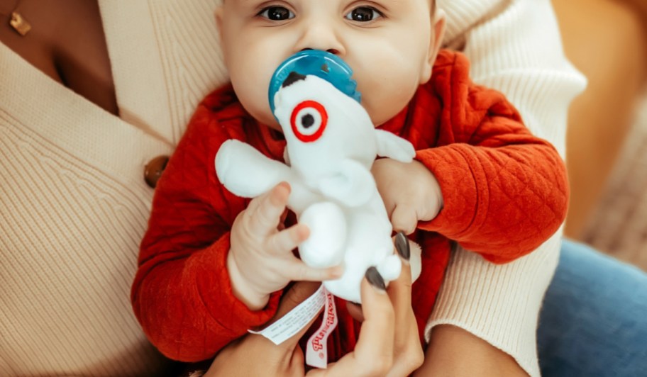 baby holding WubbaNub Pacifier with target Bullseye plush 