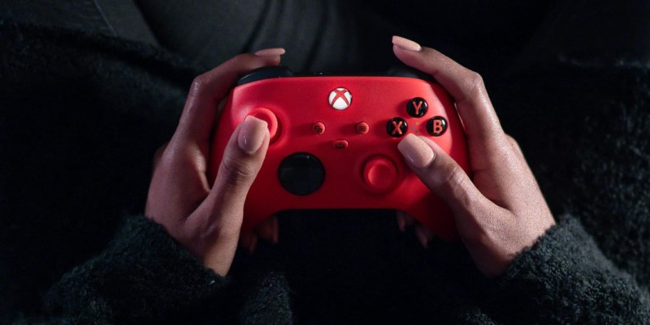 person holding red wireless xbox controller for series x or s consoles