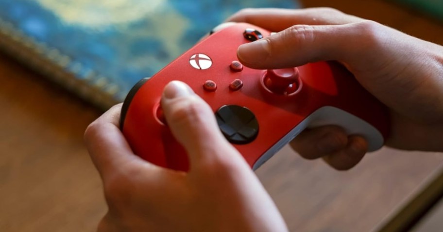 person holding red wireless xbox controller for series x or s consoles