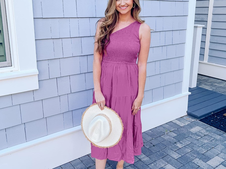 woman wearing purple dress and holding a hat