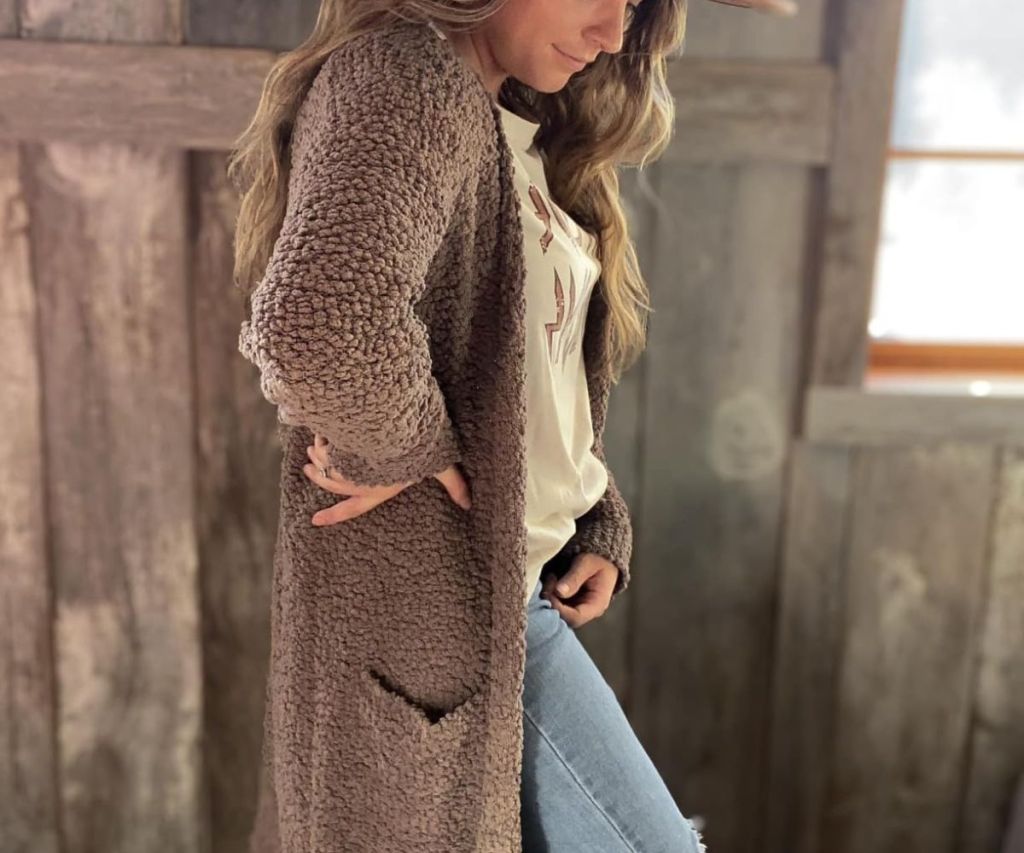 A woman wearing a ZESICA Women’s Long Sleeve Chunky Knit Cardigan in brown